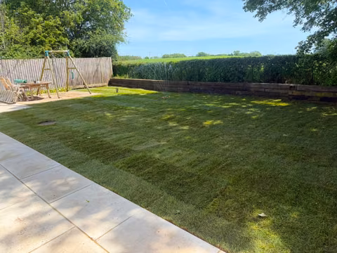 Newly turfed lawn beside a patio after garden backfilling and topsoil work in Coalpit Heath
