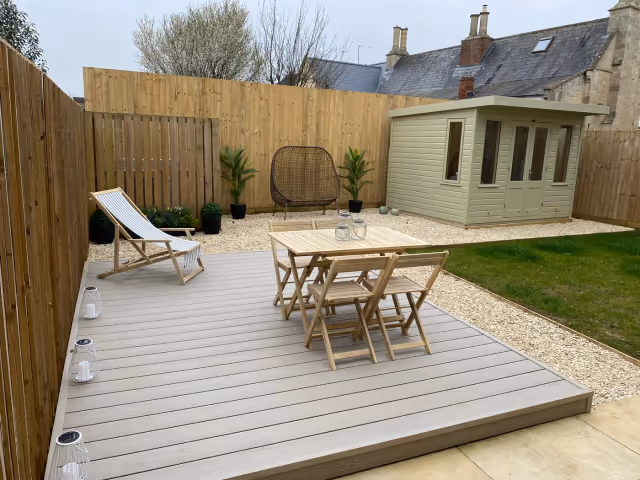 Light composite decking installed as a dining terrace in a completed garden