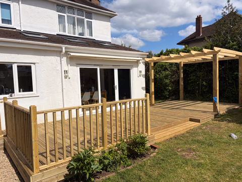 Large timber deck with balustrade, steps and pergola in a Bristol garden