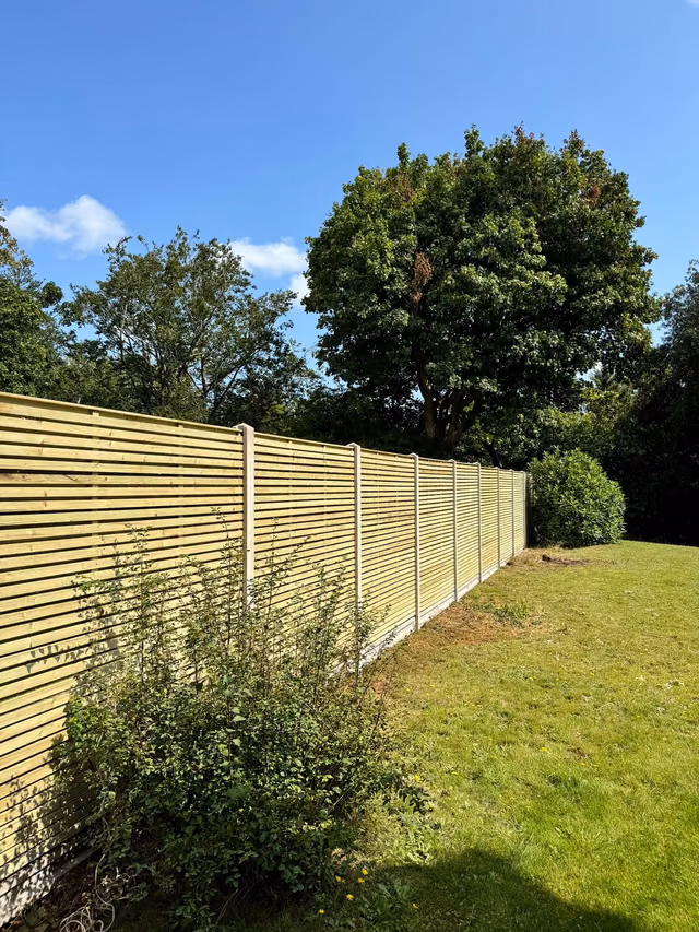 Double-sided contemporary fence panels with concrete posts and gravel boards