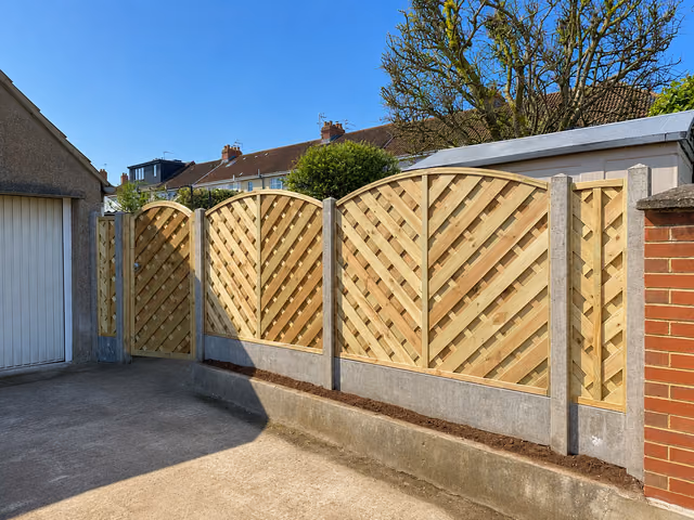 Arched Madrid fence panels with concrete posts and 12-inch gravel boards