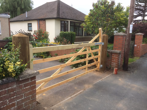 Timber field gate installed between substantial posts at a residential entrance