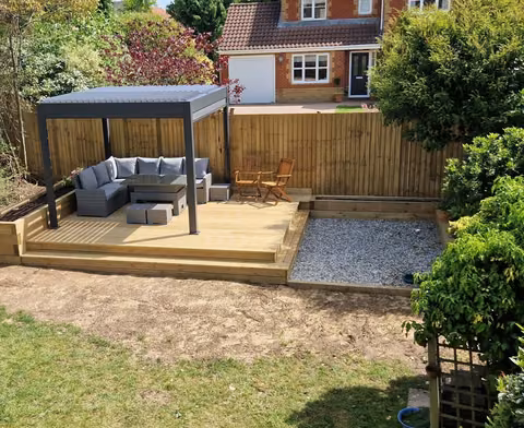 Completed garden transformation with timber decking, pergola, fencing, gravel and raised beds