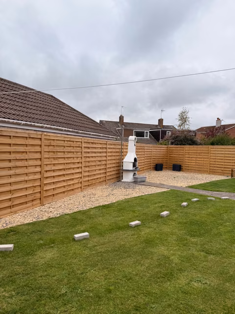 Milan timber fence panels and raised sleeper planting beds in a Winterbourne garden